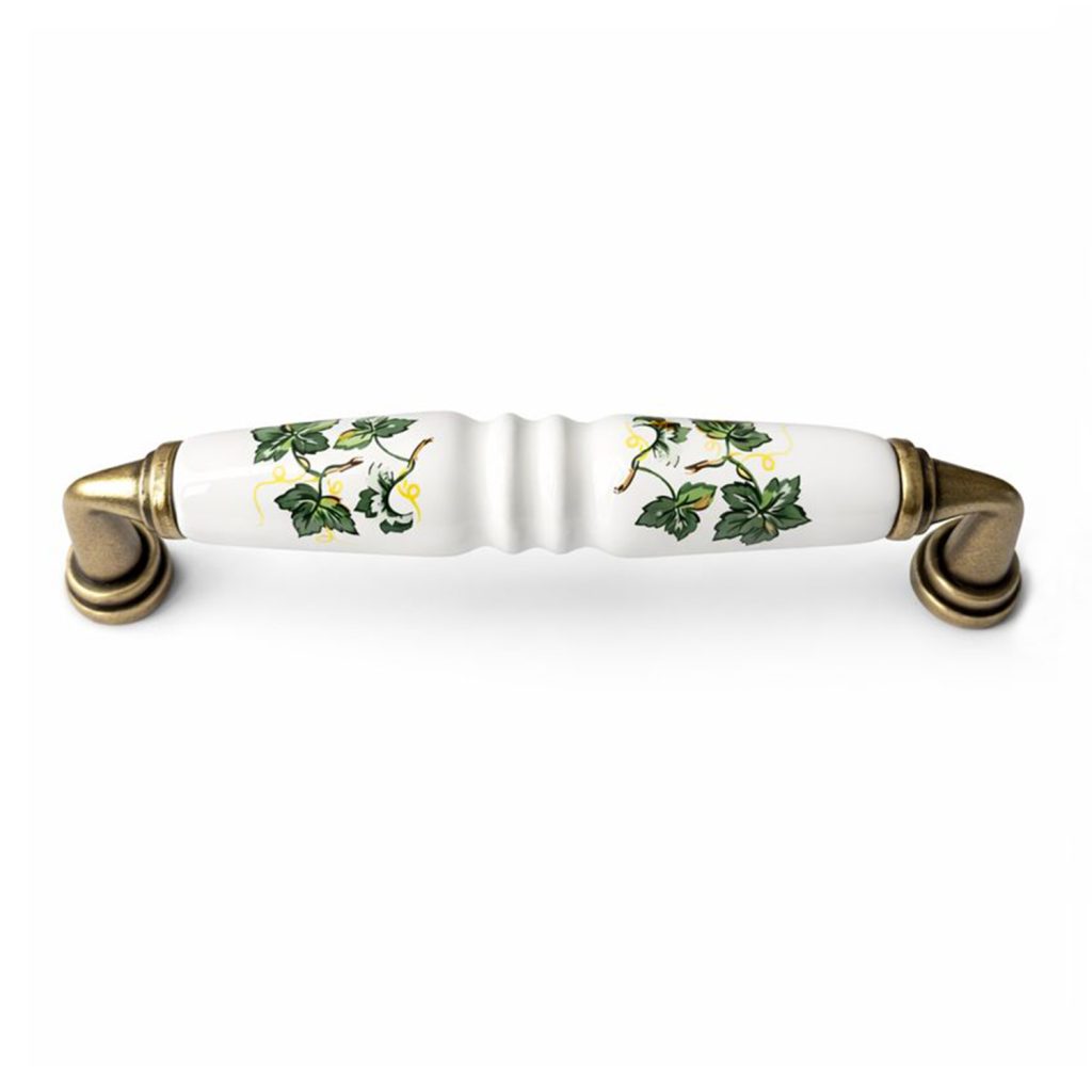 Mâner ceramic de mobilier cu decor floral verde, fotografiat pe fundal alb.